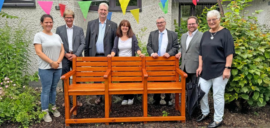 Landrat Dr. Alexander Saftig (3.v.r.), der Erste Kreisbeigeordnete Pascal Badziong (2.v.r.), Projektleiterin „Bewegung in die Dörfer“ Lea Bales (Mitte) und Berthold Nick (2.v.l.) von der evm haben jüngst die Seniorenbank an die Stadt Vallendar übergeben. Hierüber freuten sich der Pfarrer der Evangelischen Kirchengemeinde Vallendar Berg Gerd Götz (3.v.l.), Laura Steffen (links) und die Vallendarer Bewegungsbegleiterin Ingrid Brennecke (rechts). 