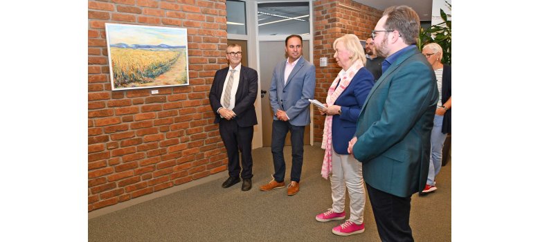 Im Rahmen der Vernissage berichtete die Künstlerin Diethilde Bender (vorne) den Teilnehmenden viel Wissenswertes zu ihren Bilder. V.l.n.r. Landrat Dr. Alexander Saftig, Kreisbeigeordneter Jens Firmenich, Künstlerin Diethilde Bender, Erster Kreisbeigeordneter Pascal Badziong.